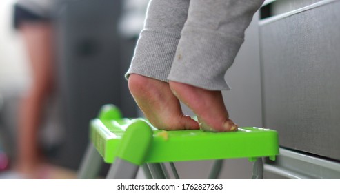 
Child Standing On Tiptoes Reaching Out At The Kitchen. One Year Old Infant Baby Tiptoe Closeup