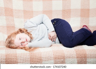 Child With Stomach Ache In Sofa