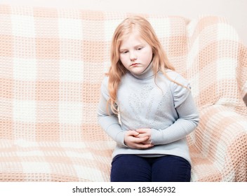 Child With Stomach Ache In Sofa