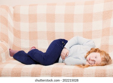 Child With Stomach Ache In Sofa