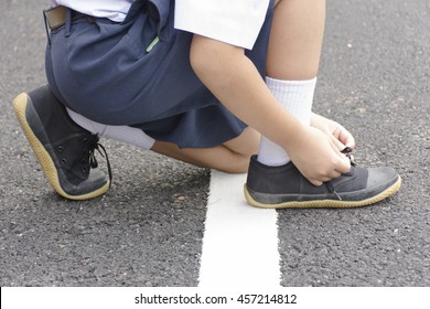 Child Student  Tying Shoes At Roadside.Zoom In