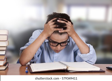 Child Studying At The Desk With The Open Book