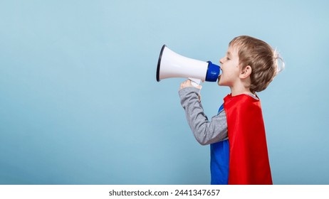 Child in superhero costume using megaphone. Blue background with copy space - Powered by Shutterstock