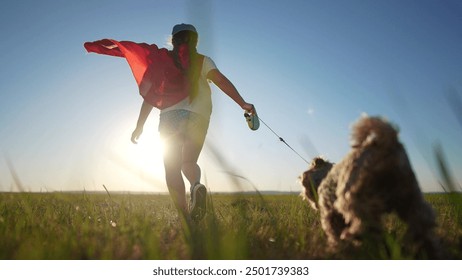 Child superhero and dog running at sunset. happy pet family concept. dog is playing with a superhero. a child runs on the grass in a park, a daughter plays at the lifestyle superhero. - Powered by Shutterstock