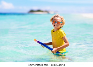 Child Surfing On Tropical Beach. Family Summer Vacation In Asia. Kids Swim In Ocean Water. Kid On Surf Body Board. Little Boy Swimming In Exotic Sea. Travel With Children. Water And Beach Sport.