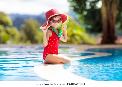 Child In Swimming Pool. Tropical Vacation For Family With Kids. Little Girl Wearing Red Swimsuit And Watermelon Sun Hat Playing In Outdoor Pool Of Exotic Island Resort. Water And Swim Fun For Children