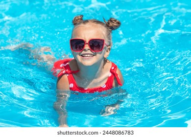 Child in swimming pool. Tropical vacation for family with kids. Little girl wearing red swimsuit playing in outdoor pool of exotic island resort. Water and swim fun for children - Powered by Shutterstock