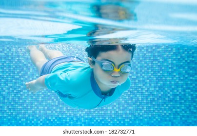 Child Swimming Underwater In The Pool 