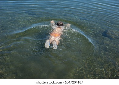 Child Swims In The Lake In The Summer