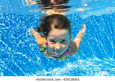 Child Swims In Pool Underwater, Happy Active Girl Has Fun Under Water, Kid Sport On Family Vacation
