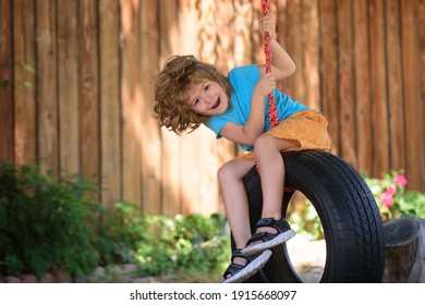 Child swing on backyard. Kid playing oudoor. Happy cute little boy swinging and having fun healthy summer vacation activity
