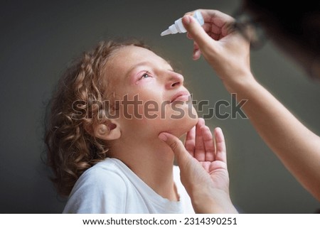 Child with swollen pink eye. Eyes infection and pollen allergy. Allergic little boy with runny nose and red eyes. Sick kid at doctor or hospital.