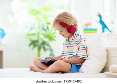 Child With Tablet Computer. Kids Study Online. Electronic Device For Learning And Studying At Home. Little Boy With Laptop Pc. Gadget And Screen Time For Children. Kid At Home. Remote School.