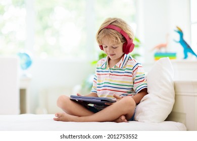 Child with tablet computer. Kids study online. Electronic device for learning and studying at home. Little boy with laptop pc. Gadget and screen time for children. Kid at home. Remote school. - Powered by Shutterstock