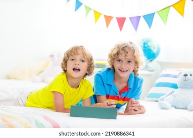 Child With Tablet Computer. Kids Study Online. Bedroom For Two Siblings. Electronic Device For Learning And Studying At Home. Little Boy With Laptop Pc. Gadget Screen Time For Children. Kid At Home. 