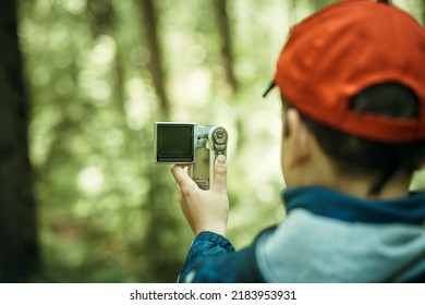 A Child Takes A Video On A Camera In Nature.Video Blogger. Shooting With A Video Camera Is A News Story.