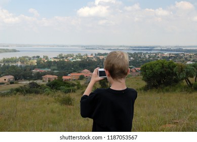 Child Taking A Photo Of The View Over The Dam