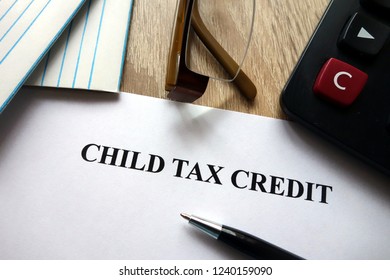 Child Tax Credit Document With Pen, Calculator And Glasses On Desk