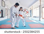 Child, teacher or practice in dojo for martial arts, training or fighting exercise for karate education. Learning skill, warrior or judo master with girl kid in studio for taekwondo lesson or workout