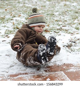 Child Toddler Falling On Icy Slippery Pavement Or Sidewalk In Winter. 