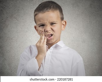 Child Toothache. Closeup Portrait Boy With Sensitive Tooth Ache Crown Problem Touching Outside Mouth With Hand Isolated Grey Wall Background. Negative Human Emotion, Facial Expression Feeling Reaction