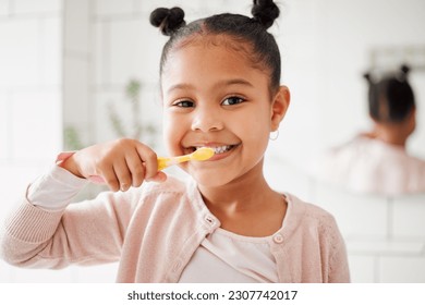 Child, toothbrush and brushing teeth in a home bathroom for dental health and wellness with smile. Face portrait of african girl kid cleaning mouth with a brush for morning routine and oral self care - Powered by Shutterstock