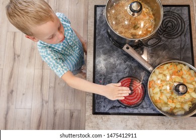 Child touches hot stove in the home. Dangerous situation in the kitchen