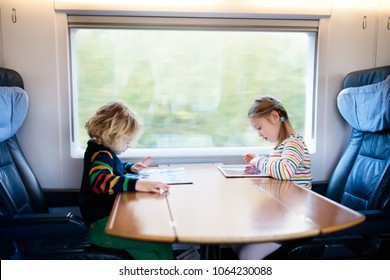 Child traveling by train. Little kid in a high speed express train on family vacation in Europe. Travel by railway. Children in railroad car. Kids in rail way wagon. Entertainment for young passenger.