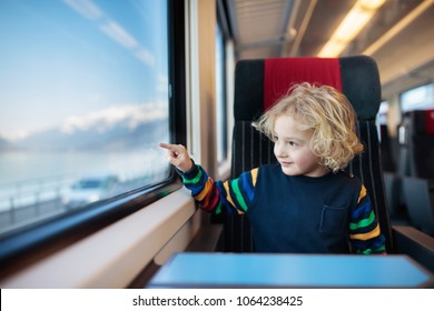 Child traveling by train. Little kid in a high speed express train on family vacation in Europe. Travel by railway. Children in railroad car. Kids in rail way wagon. Entertainment for young passenger.
