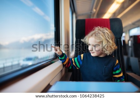 Child traveling by train. Little kid in a high speed express train on family vacation in Europe. Travel by railway. Children in railroad car. Kids in rail way wagon. Entertainment for young passenger.