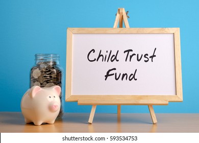 Child Trust Fund, Financial Concept. Mason Jar With Coins Inside, Piggy Bank And Whiteboard On Wooden Table.