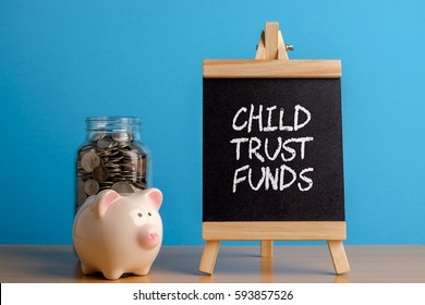 Child Trust Fund, Financial Concept. Mason Jar With Coins Inside, Piggy Bank And Chalkboard On Wooden Table.