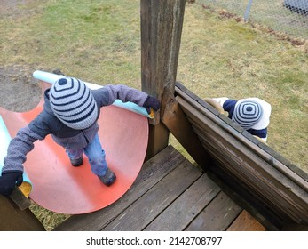 A Child Trying To Climb Up A Slide The Wrong Way.