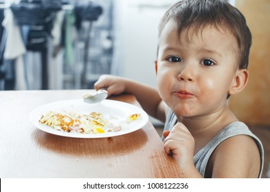 Child T-shirt In The Kitchen Eating Scrambled Eggs, With A Spoon