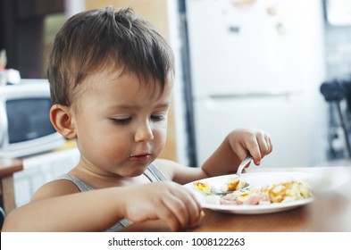 Child T-shirt In The Kitchen Eating Scrambled Eggs, With A Spoon