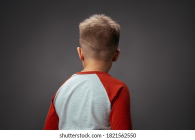 Child Turned His Back To The Camera. Children's Drama Concept. Boy Offended By Isolated Background. High Quality Photo.