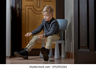 Child Tying His Shoelaces For Himself, Children Learning At Home To Help Himself With Difficult Task.