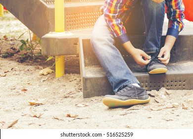 Child   Tying Shoes In The Playground.Zoom In.