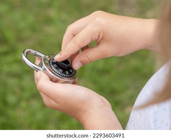 Child unlocking a simple closed coded lock, holding a code padlock in hands. Password cracking, encryption and decryption, hacking, cracking abstract concept, kids, children cyber security, object - Powered by Shutterstock - Get 15% off with code: PIKWIZARD15