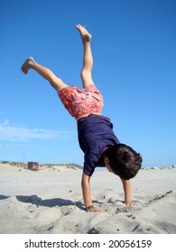 Child upside down in the beach
