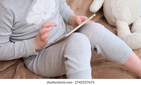 Child using digital tablet, a boy interacting with a device. Early childhood development and digital literacy for kids. Online education.
