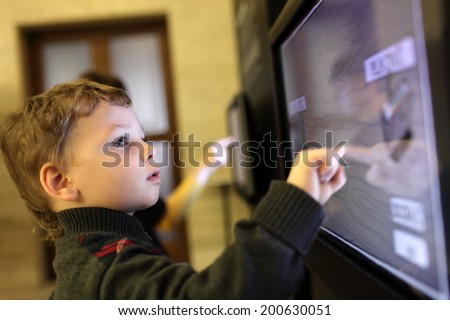 Child using interactive touch screen in a museum