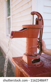 Child Using An Old Red Water Pump