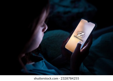 A child using smart phone lying in bed late at night, playing games. Children's screen addiction and parent control concept. Child's room at night. Sensitive content on screen - Powered by Shutterstock