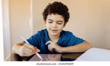 Child using tablet with stylus, focused on screen. Young boy, curly hair, engaged with technology. Tablet, stylus, and learning at home. Child learning with tablet. Home school and technology concept. - Powered by Shutterstock