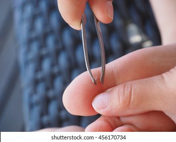 Child Using Tweezers On Big Toe For Removal Of A Splinter In A Callus