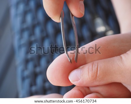 child using tweezers on big toe for removal of a splinter in a callus