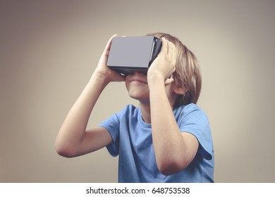 Child Using VR Cardboard Glasses. Toned Image