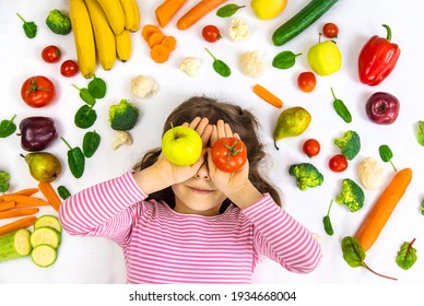 A Child With Vegetables And Fruits In Their Hands. Selective Focus. Food.