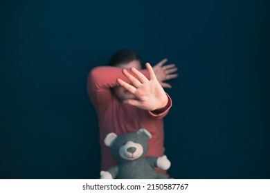 Child Violence And Abused Concept. Little Girl Sitting In A Dark Room, Showing Stop Sign